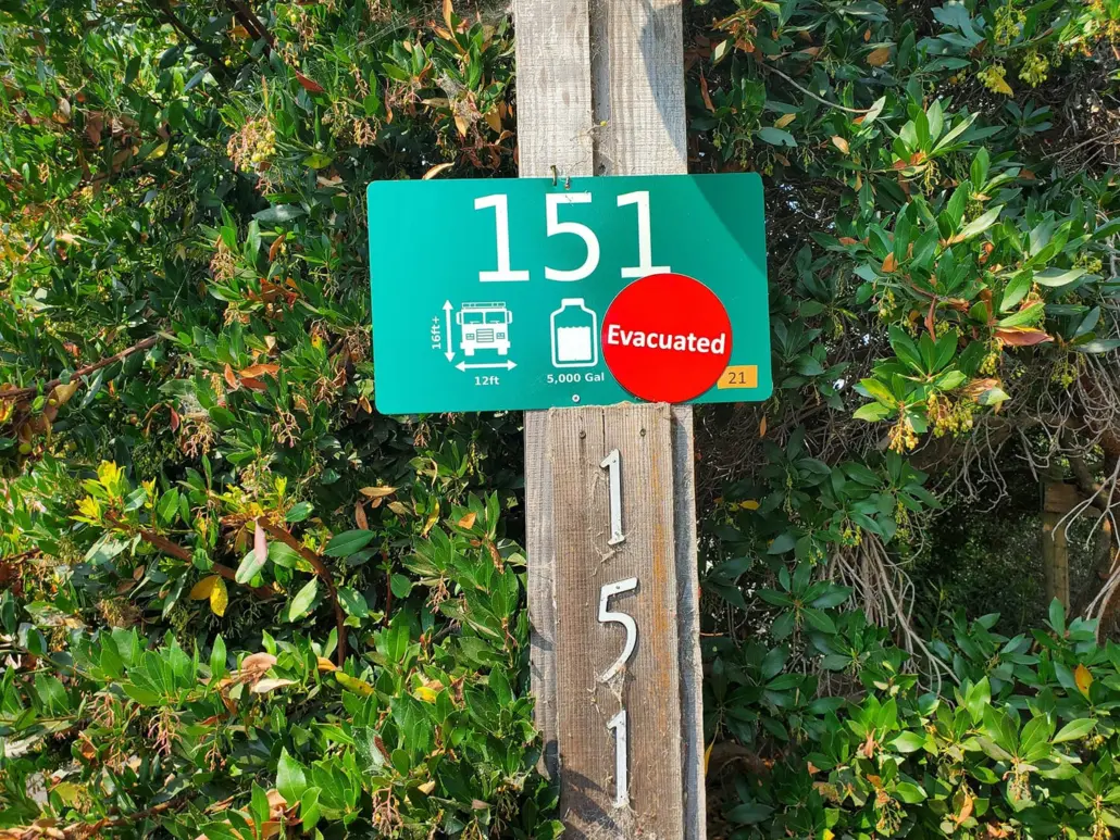 Fire Safe Sign 151 with an Evacuated sticker on a wooden post