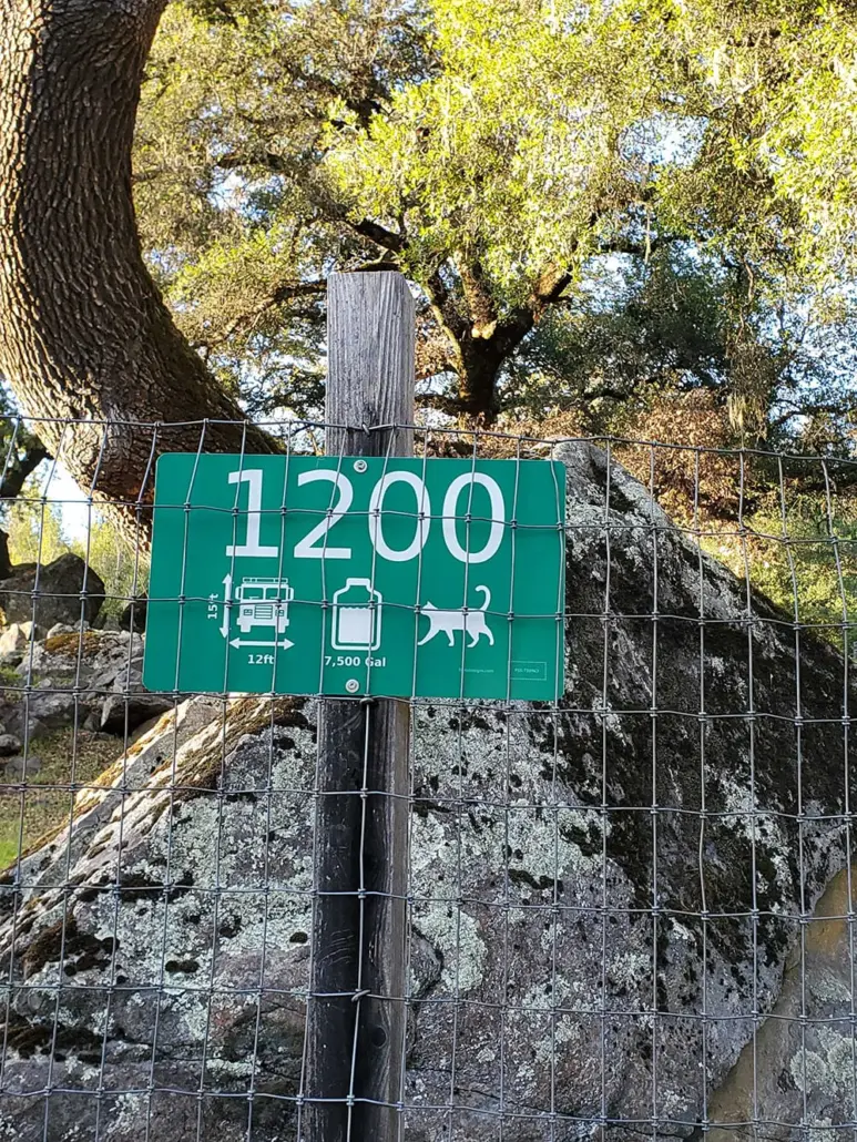 Fire Safe Sign 1200 on a fence post beside an oak tree