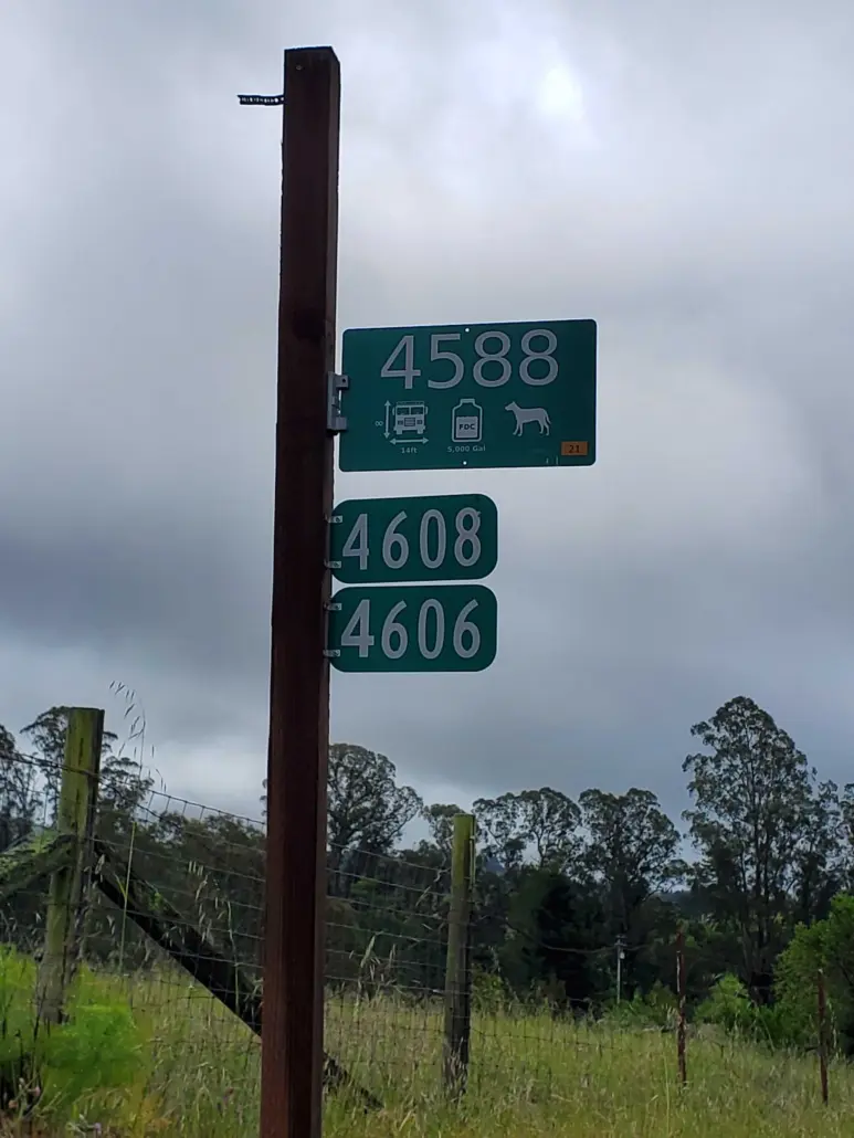 Fire Safe Sign 4588 on a tall post above neighbouring address signs